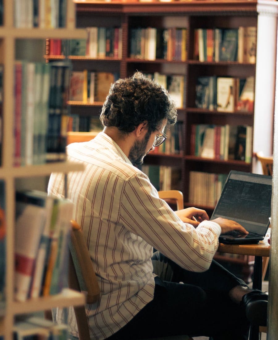 Researcher working on a laptop in a library setting