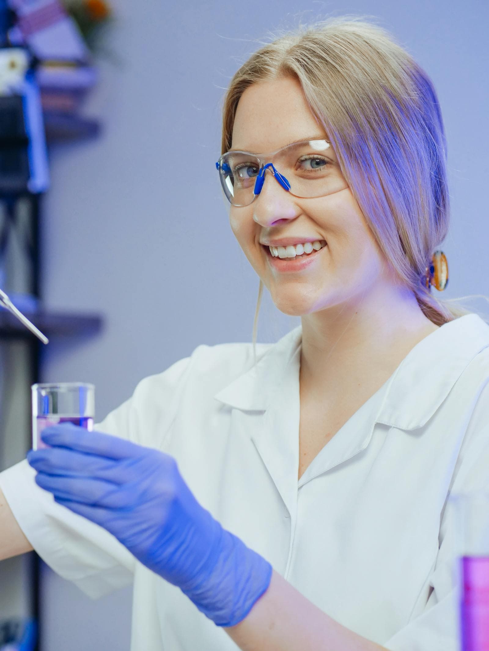 A doctor in a white coat smiling during lab research